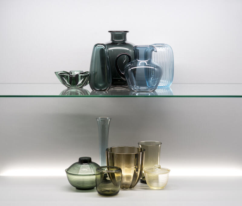 in einer Vitrine stehen farblich fein aufeinander abgestimmte Vasen von Wilhelm Wagenfeld. Das Farbspektrum reicht von kühlen Blau und Grüntönen bis zu warmen beige-Tönen