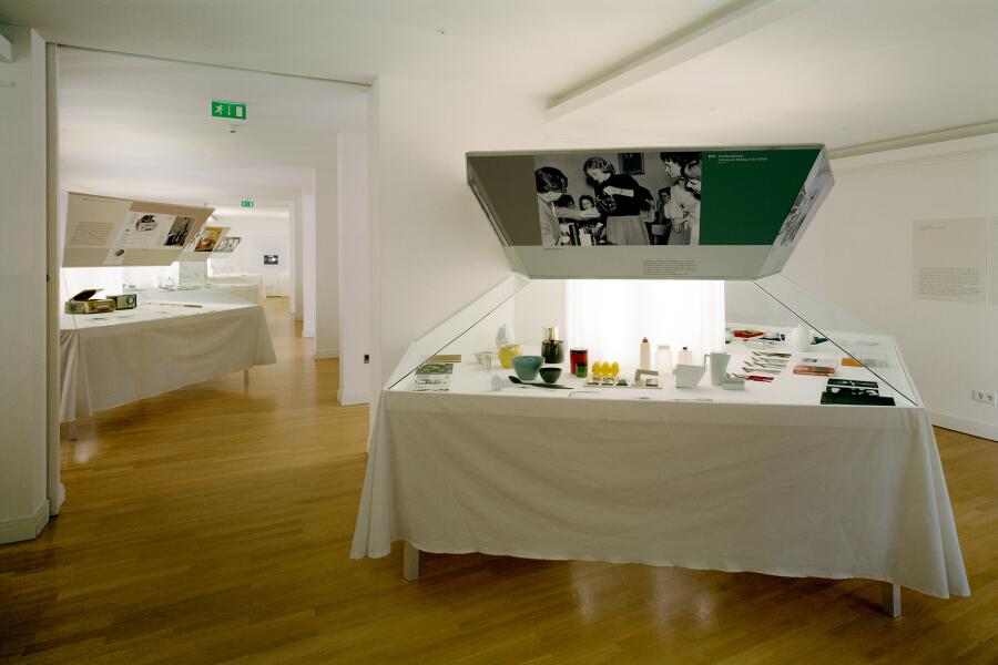 Die Ausstellungselemente sehen aus wie große sechseckige Tische, auf denen Objekte arrangiert wurden.