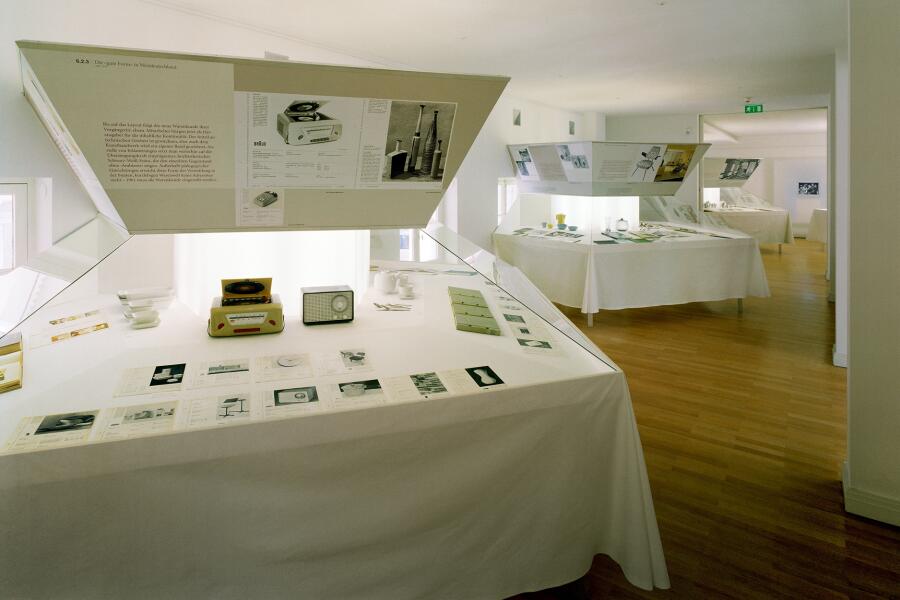 Die Ausstellungselemente sehen aus wie große sechseckige Tische, auf denen Objekte arrangiert wurden.